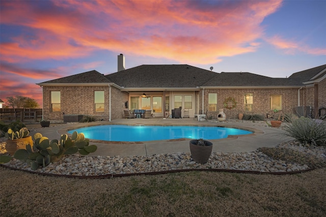 pool at dusk with a patio