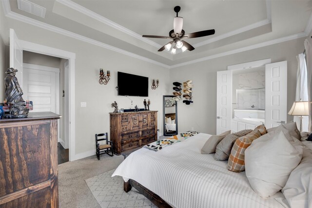 carpeted bedroom with ceiling fan, a tray ceiling, and ornamental molding