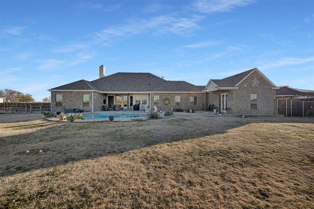 rear view of house with a lawn and a patio