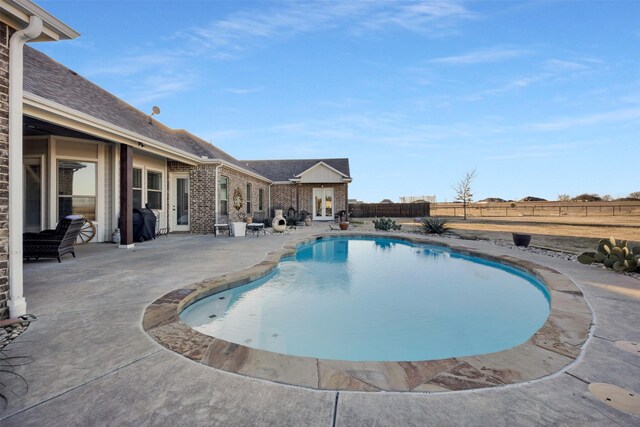 view of swimming pool featuring a patio and french doors