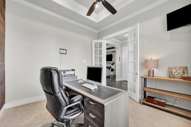 office space with light carpet, a raised ceiling, ceiling fan, and ornamental molding