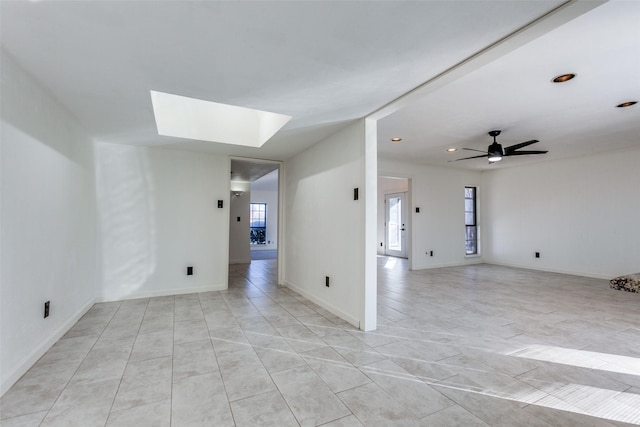 spare room with ceiling fan and a skylight