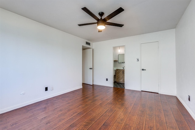 unfurnished bedroom featuring ceiling fan, ensuite bathroom, and dark hardwood / wood-style floors