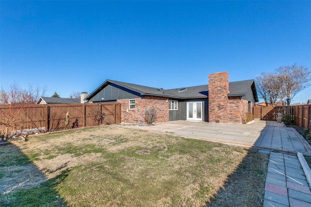 rear view of property with a yard, french doors, and a patio