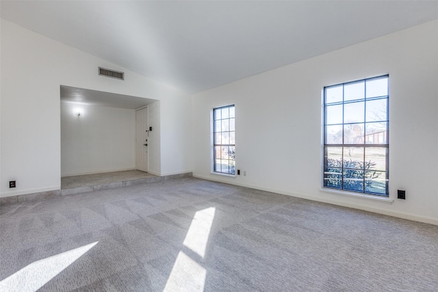 carpeted empty room with lofted ceiling