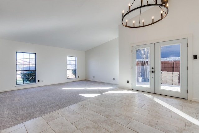 interior space featuring a chandelier, french doors, and light colored carpet