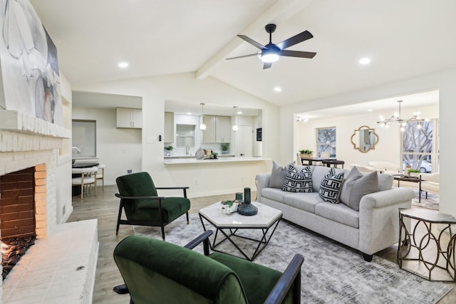 living room with ceiling fan with notable chandelier, a brick fireplace, vaulted ceiling with beams, and wood-type flooring