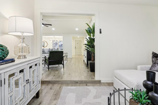 corridor featuring a notable chandelier and light hardwood / wood-style floors