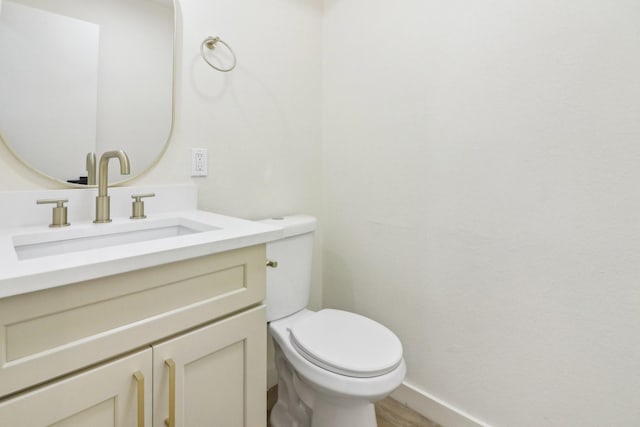 bathroom featuring vanity, toilet, and hardwood / wood-style flooring