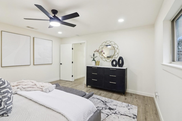 bedroom with ceiling fan, light hardwood / wood-style floors, and multiple windows