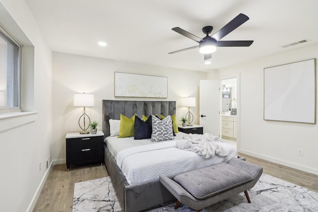 bedroom featuring ceiling fan, light hardwood / wood-style floors, and ensuite bathroom