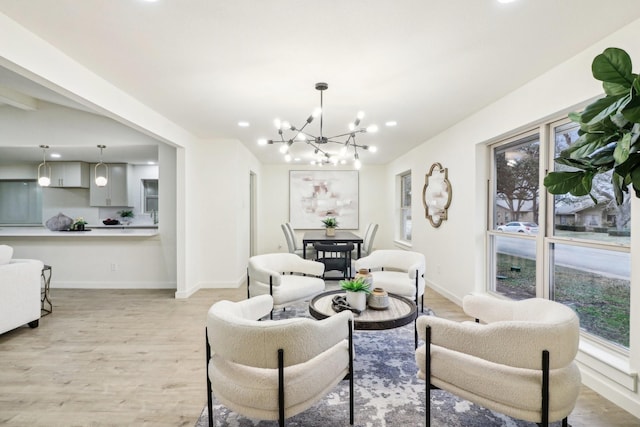 living room with an inviting chandelier and light hardwood / wood-style flooring