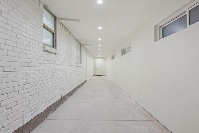 hallway featuring brick wall