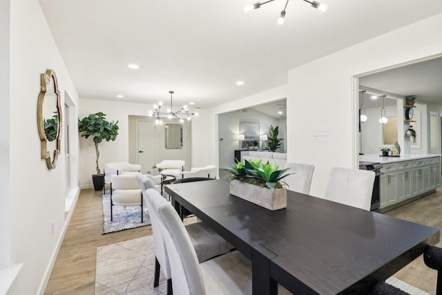 dining room featuring light wood-type flooring and a notable chandelier