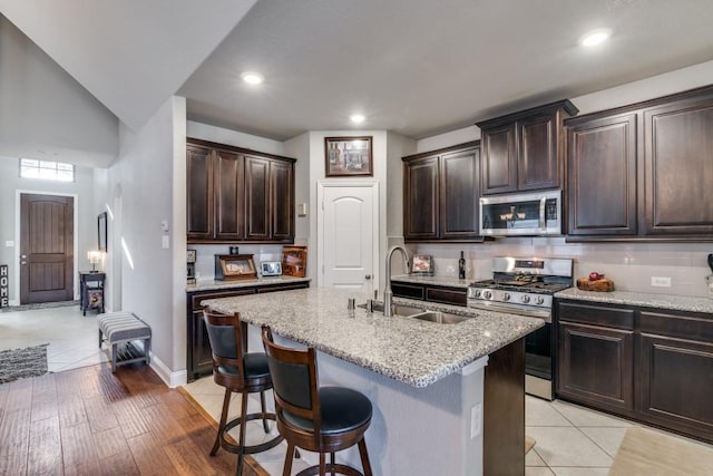1625 Veneto Dr, Mclendon Chisholm, TX 75032 - kitchen with dark brown cabinets, light stone countertops, stainless steel appliances, and a sink