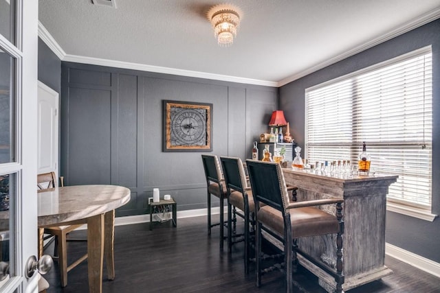 dining area with crown molding and dark wood-type flooring