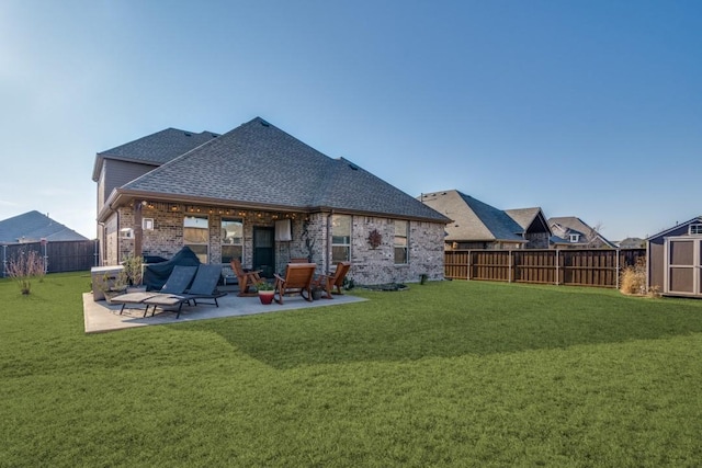 back of property with a patio, a yard, and a storage unit