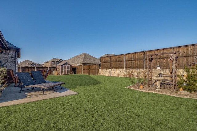 view of yard with a shed and a patio area