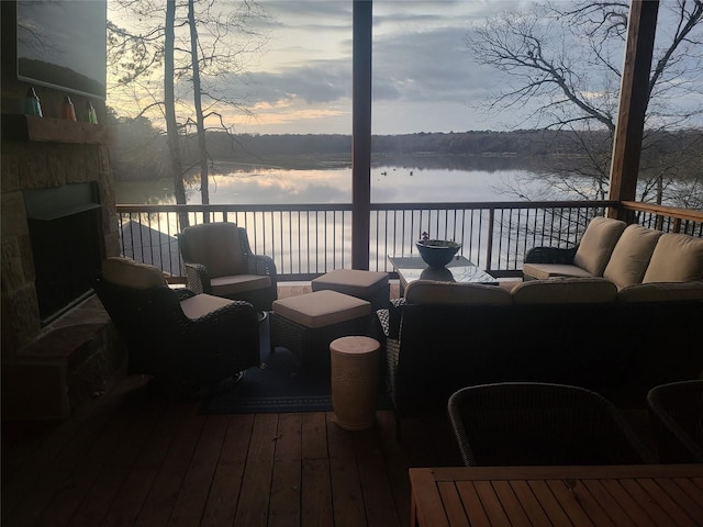 deck at dusk featuring an outdoor living space and a water view