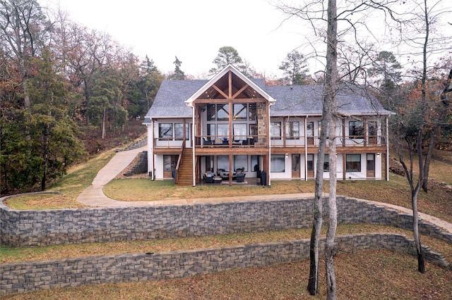 rear view of house with a deck and a yard