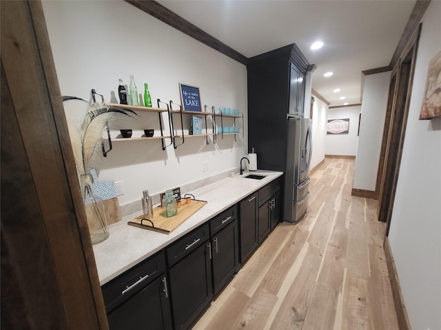 bathroom featuring sink, hardwood / wood-style flooring, and ornamental molding