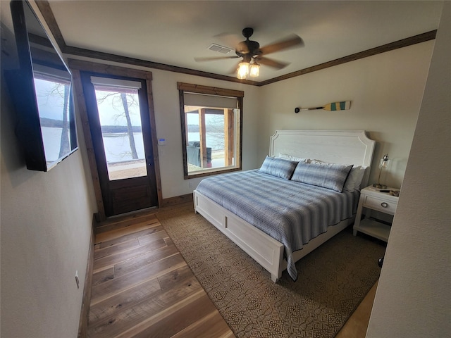 bedroom featuring ceiling fan, a water view, crown molding, and dark wood-type flooring