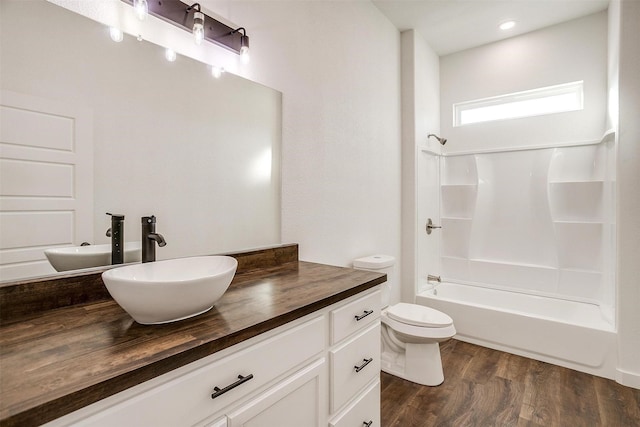 full bathroom featuring shower / bath combination, hardwood / wood-style floors, toilet, and vanity