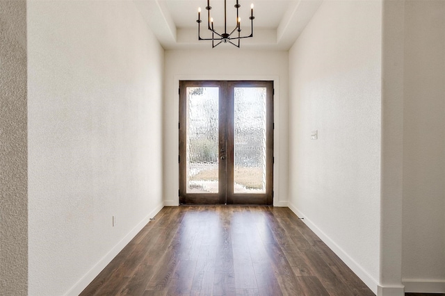 doorway to outside featuring dark hardwood / wood-style flooring, an inviting chandelier, and french doors