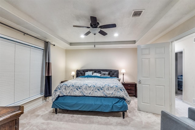 carpeted bedroom featuring ceiling fan, ornamental molding, and a tray ceiling