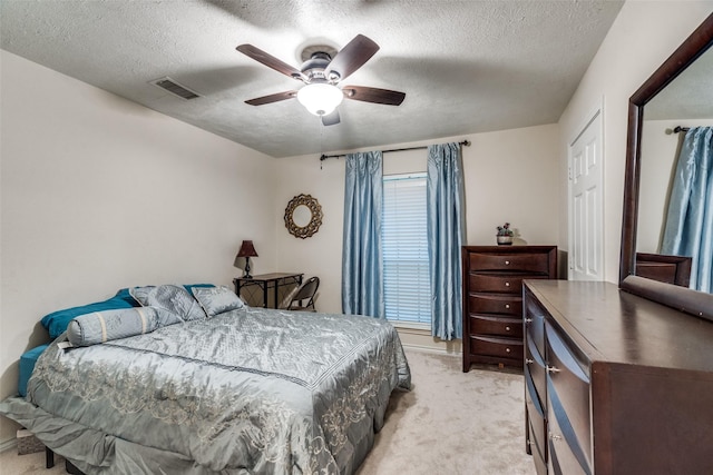 carpeted bedroom with a textured ceiling and ceiling fan