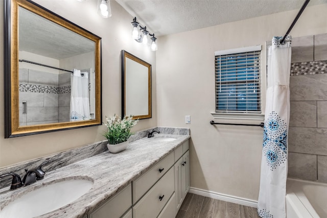 bathroom with vanity, shower / tub combo, and a textured ceiling