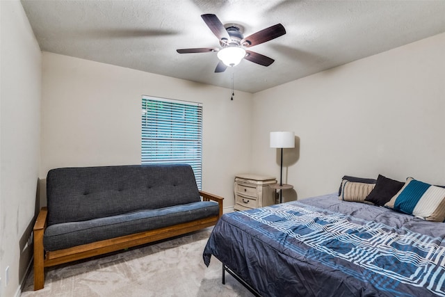 carpeted bedroom with ceiling fan and a textured ceiling