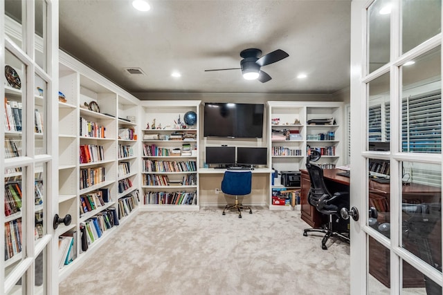 carpeted office space featuring ceiling fan