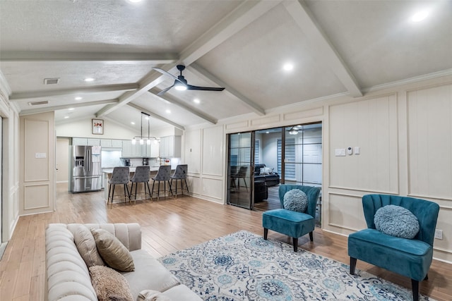 living room with a textured ceiling, lofted ceiling with beams, light hardwood / wood-style flooring, and ceiling fan