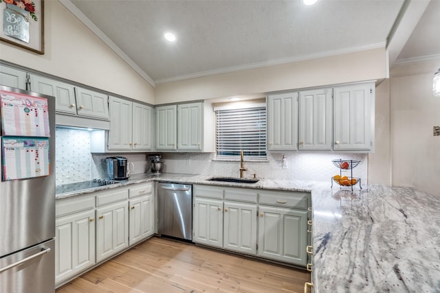 kitchen with sink, tasteful backsplash, light stone countertops, and appliances with stainless steel finishes