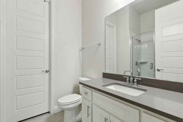 bathroom with a shower with door, vanity, tile patterned floors, and toilet