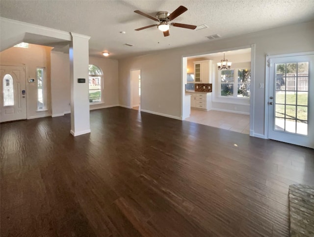 unfurnished living room with ceiling fan with notable chandelier, dark hardwood / wood-style floors, and a textured ceiling