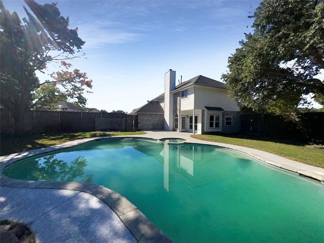 view of swimming pool with an in ground hot tub and a lawn