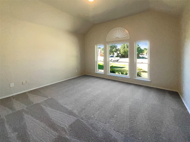 carpeted spare room with vaulted ceiling