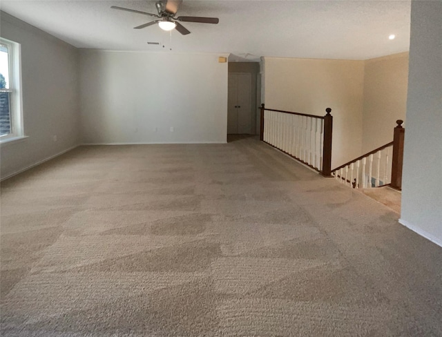 carpeted spare room featuring ceiling fan