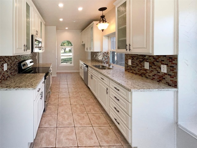 kitchen featuring pendant lighting, sink, white cabinetry, light tile patterned floors, and stainless steel appliances