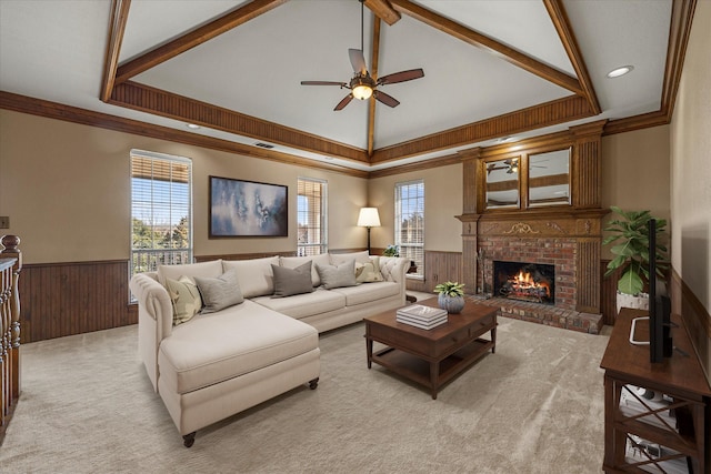 carpeted living room featuring ceiling fan, crown molding, vaulted ceiling, and a fireplace