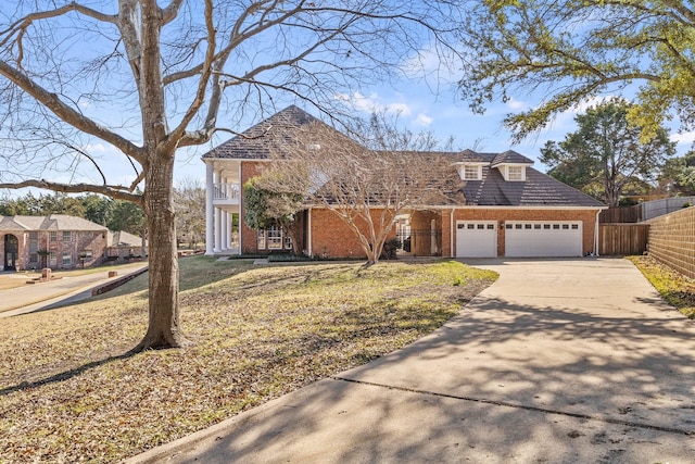 view of front of home with a front yard, a balcony, and a garage