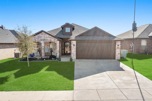 view of front of home with central AC, a garage, and a front yard