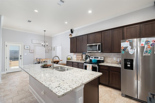 kitchen featuring an island with sink, sink, ornamental molding, light stone counters, and stainless steel appliances