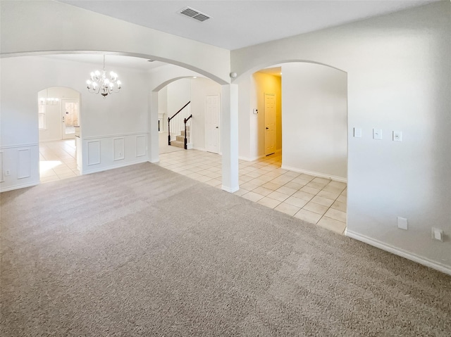 carpeted empty room with a notable chandelier