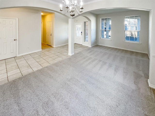 unfurnished room featuring light tile patterned floors, ornamental molding, and a chandelier