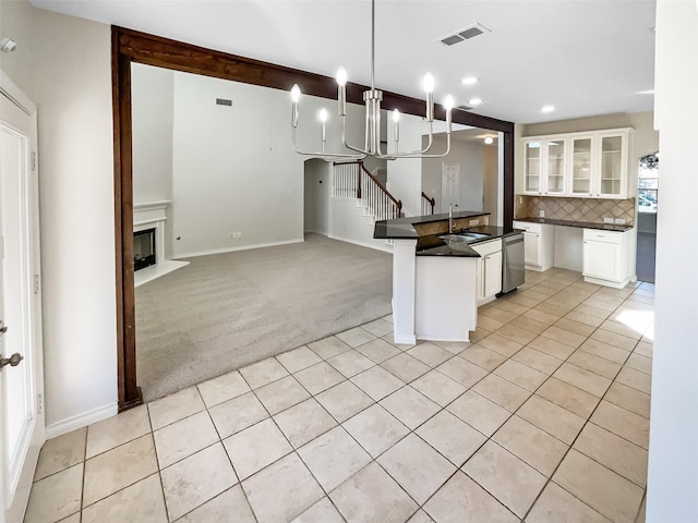 kitchen with white cabinetry, light carpet, tasteful backsplash, sink, and hanging light fixtures