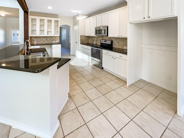 kitchen with sink, white cabinetry, light tile patterned floors, and stainless steel appliances