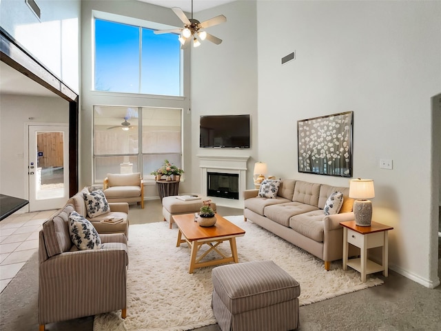 living room featuring ceiling fan, a high ceiling, and light tile patterned flooring